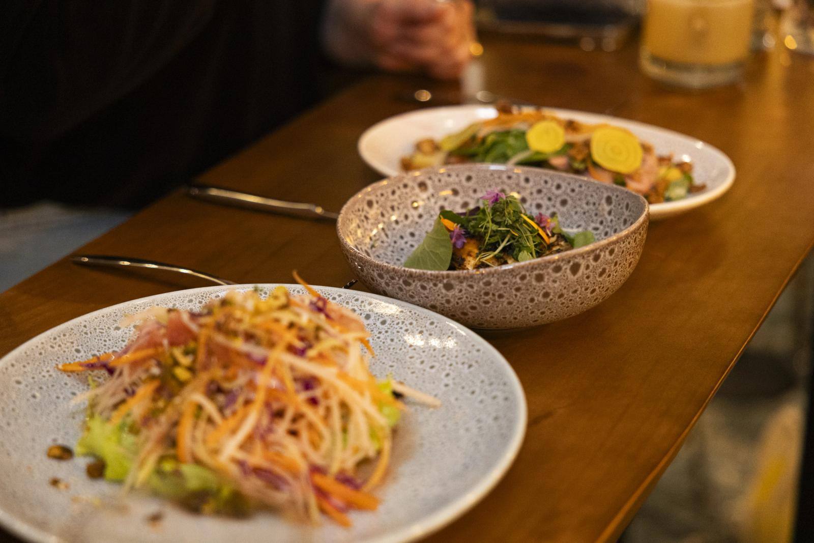 Plated dishes on the wooden counter at Rotation Napa