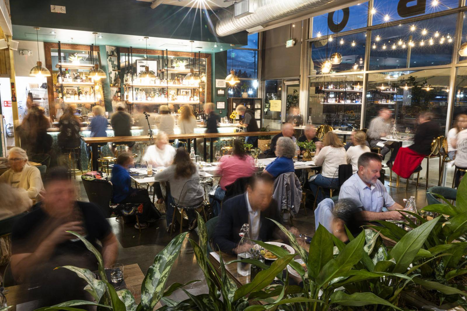 Evening service at Rotation Napa, with the bar lit behind a full dining room