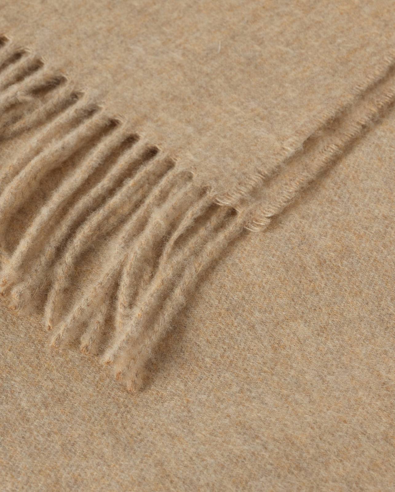 Close detail of the Johnstons of Elgin Plain Cashmere Throw in oatmeal, showing the woven texture and fringe
